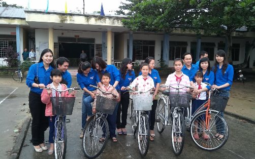 Bí thư Chi đoàn Sở Công Thương Nguyễn Thị Thanh Tâm (đầu tiên từ trái qua) tặng xe đạp cho trẻ em nghèo xã Duy Sơn